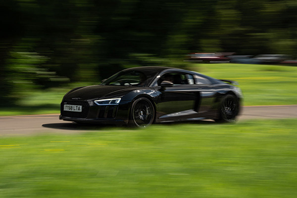 Black Audi R8 driving along grass a verge