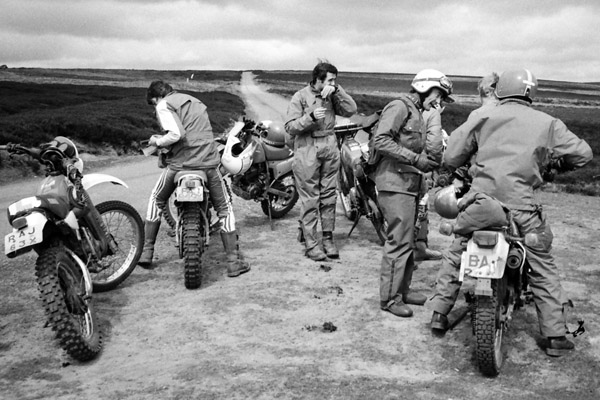 A black and white photo of a group of men sitting on classic bikes