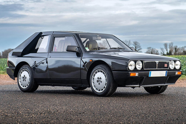 Dark green Lancia Delta against a grey sky