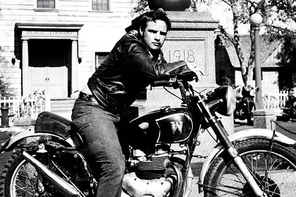 Marlon Brando Sitting On A Black 1950 Triumph Thunderbird 6T From The Wild One Film With A War Memorial And Public Library Backdrop