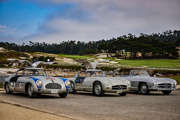 3 silver Mercedes Benz 300SL parked beside a golf course