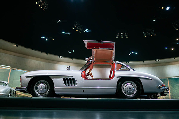 Silver Mercedes Benz 300SL Gullwings  on a platform in a showroom